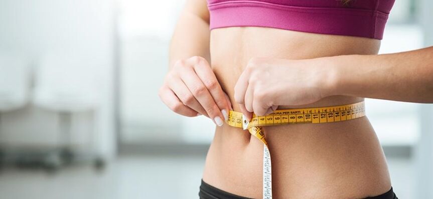 La fille mesure le tour de taille
